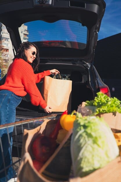 women put grocery to car trunk